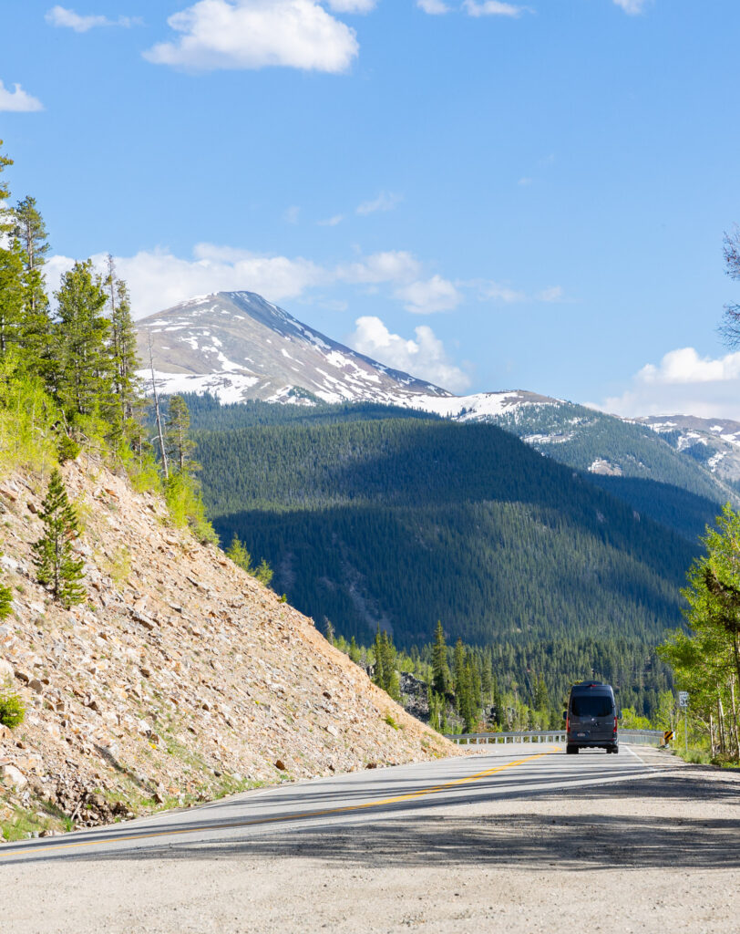 Summit Black Car SUV cruising a Colorado mountain highway
