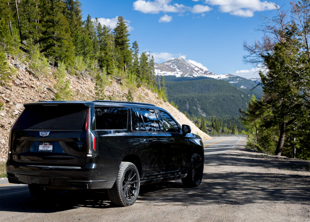 Summit Black Car Cadillac Escalade driving on I-70 in Colorado
